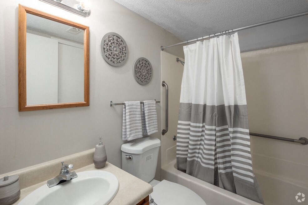 a bathroom with a shower curtain and a sink and a toilet