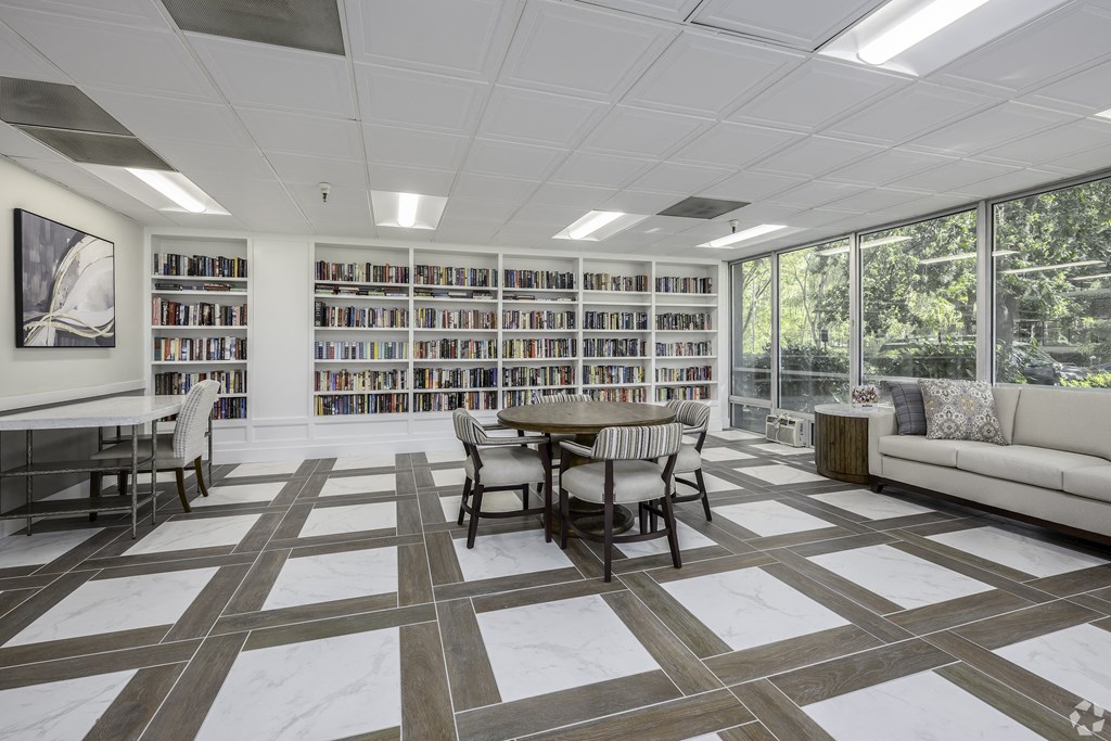 a room with a library and a table and chairs