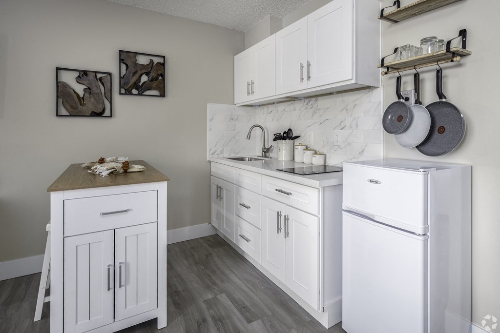 a kitchen with white cabinets and stainless steel appliances and a white refrigerator