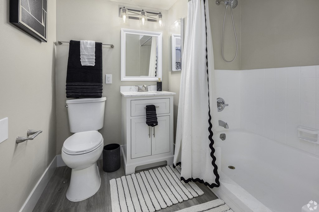 a white bathroom with a white toilet and a shower