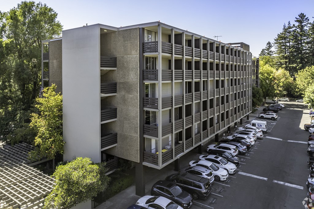 an office building with cars parked in a parking lot