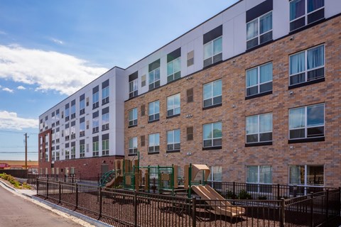 a large brick building with a playground in front of it