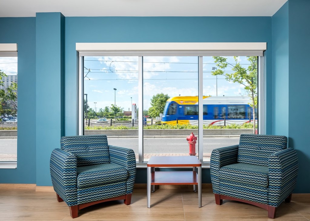 a waiting room with two chairs and a window with a train