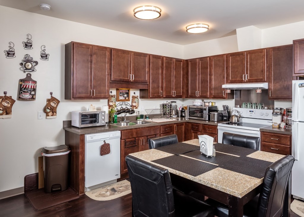 a kitchen with wooden cabinets and a table