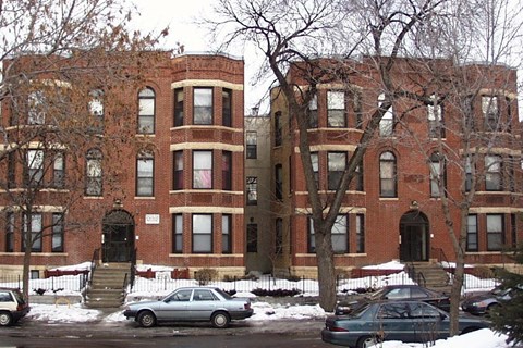 A red brick building with a black door and windows.