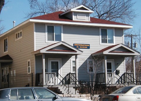A two story house with a car parked in front.