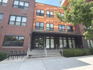 The image shows a building with a glass entrance and a sign that reads "LOVE".