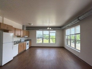 A kitchen with white appliances and wooden cabinets.