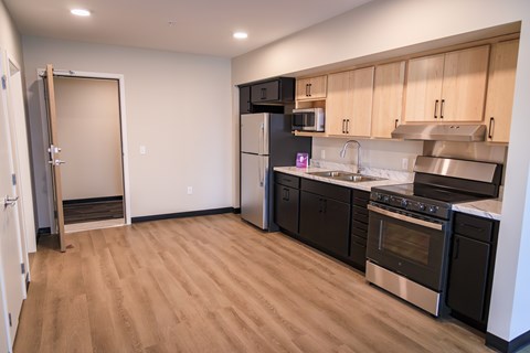 A kitchen with black appliances and wooden cabinets.