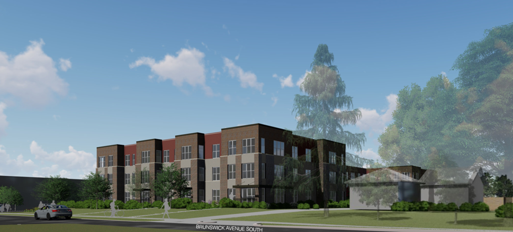 A modern building with a mix of brick and dark panels is surrounded by greenery and a clear sky.