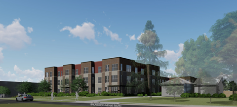 A modern building with a mix of brick and dark panels is surrounded by greenery and a clear sky.