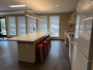 A kitchen with a long counter and bar stools.