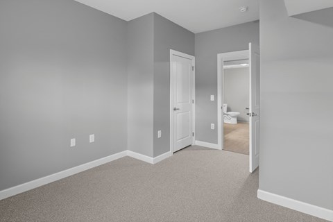 a bedroom with a door to a bathroom and a closet