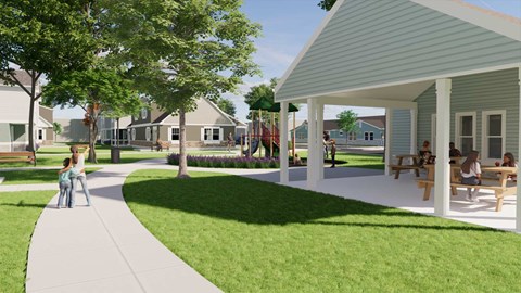 A park with a pavement, trees, and a building with a porch.