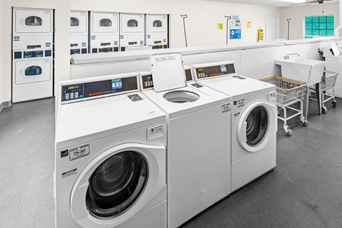 A row of industrial washing machines in a laundromat.