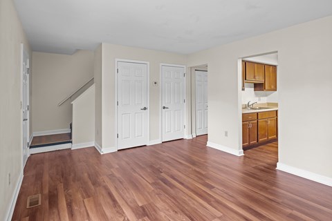 A room with wood flooring and white walls.