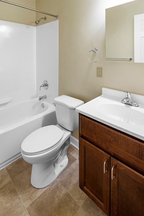 A white toilet sits next to a white sink in a bathroom.