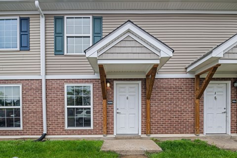 A house with a white door and a window with a white frame.
