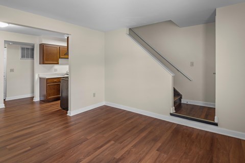 A room with wooden floors and a staircase.