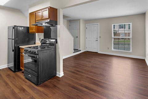 A kitchen with black appliances and wooden cabinets.