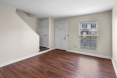A room with wooden floors and two white doors.