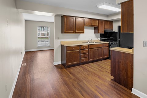A kitchen with wooden cabinets and a black refrigerator.