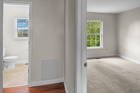 A room with a toilet and a window.