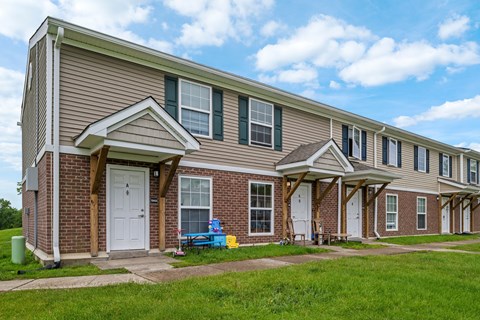 A long brick building with a white door and windows.