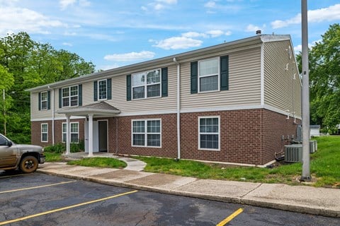 A two-story building with a parking lot in front.