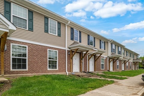 A long row of houses with green lawns in front.