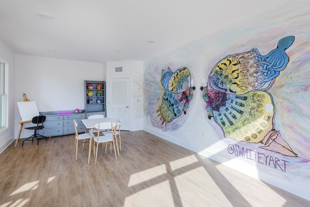 a dining room with two paintings on the wall and a table and chairs at The Merchant Apartments, South Carolina