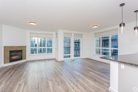 A spacious living room with a fireplace and large windows.