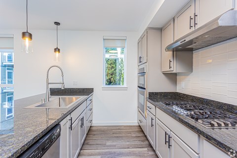 A kitchen with granite countertops and stainless steel appliances.