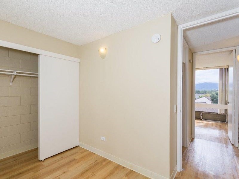 an empty room with a hard wood floor and a closet at Palms of Kilani Apartments, Wahiawa, HI
