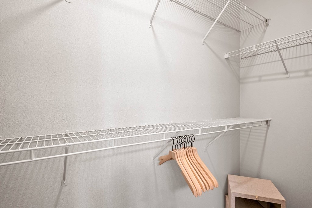 the walk in closet in the master bedroom has a wire shelf and a dresser at Mission Gate, Plano, Texas