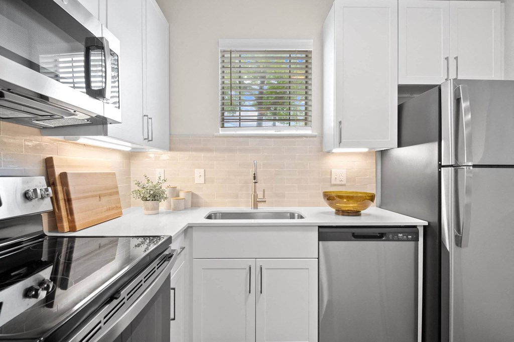 a white kitchen with stainless steel appliances and white cabinets at Mission Gate, Texas