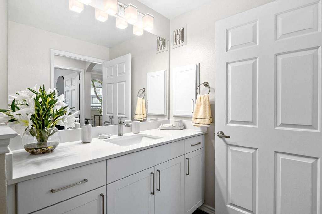 a white bathroom with two sinks and a mirror at Mission Gate, Plano