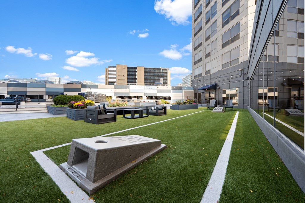 an outdoor lawn with lawn chairs and tables in front of a building at Presidential Towers, Chicago, IL, 60661