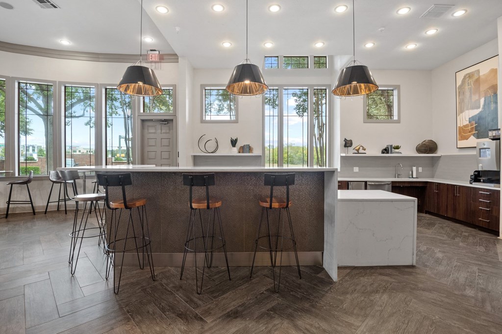 a kitchen with a marble counter top and bar stools at Mission Gate, Plano, Texas