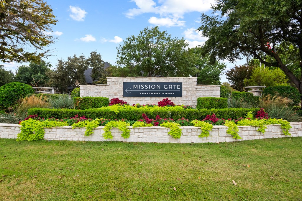 Welcoming Gate surrounded by grass and well manicured landscaping at Mission Gate in Plano TX