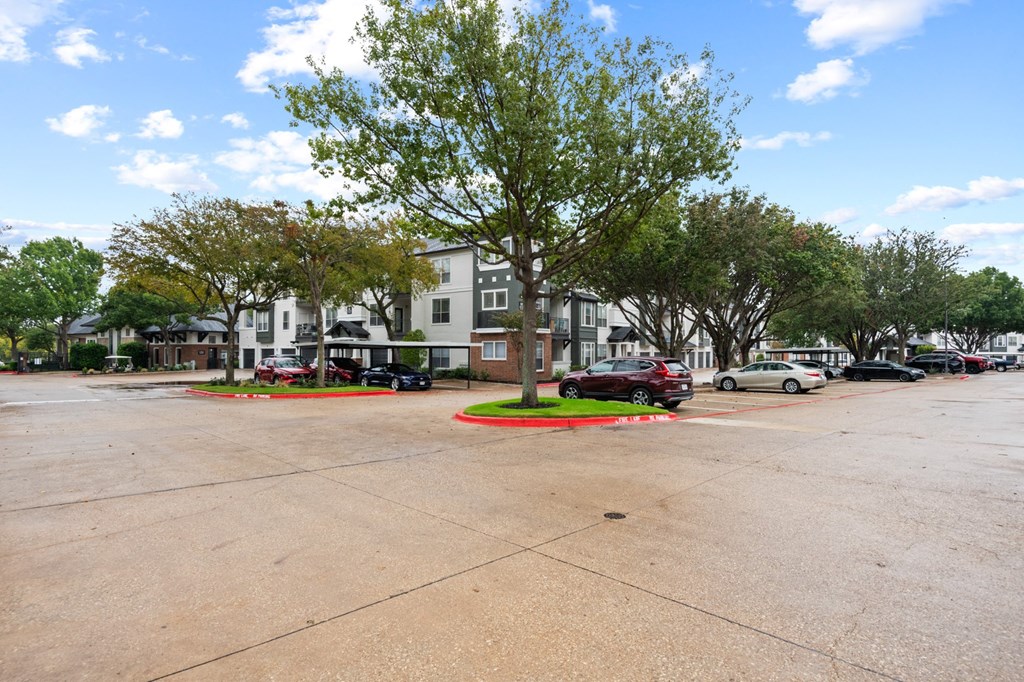a parking lot with cars parked in front of a building at Mission Gate, Texas, 75024