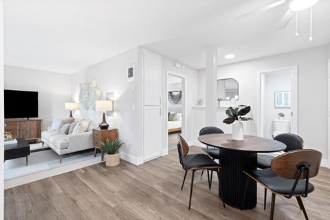 a living room and dining room with a table and chairs
