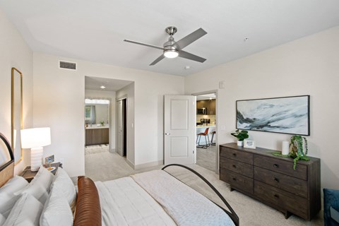Spacious bedroom with ceiling fan and ensuite bathroom at Aventine Apartments, California