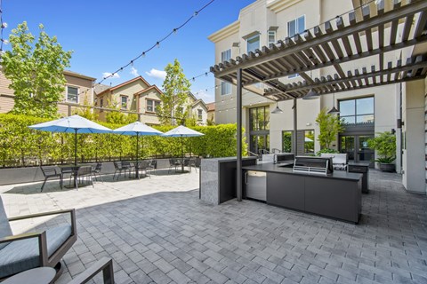 A patio with a bar and umbrellas.