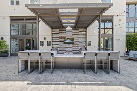 A patio with a table and chairs is in front of a building.
