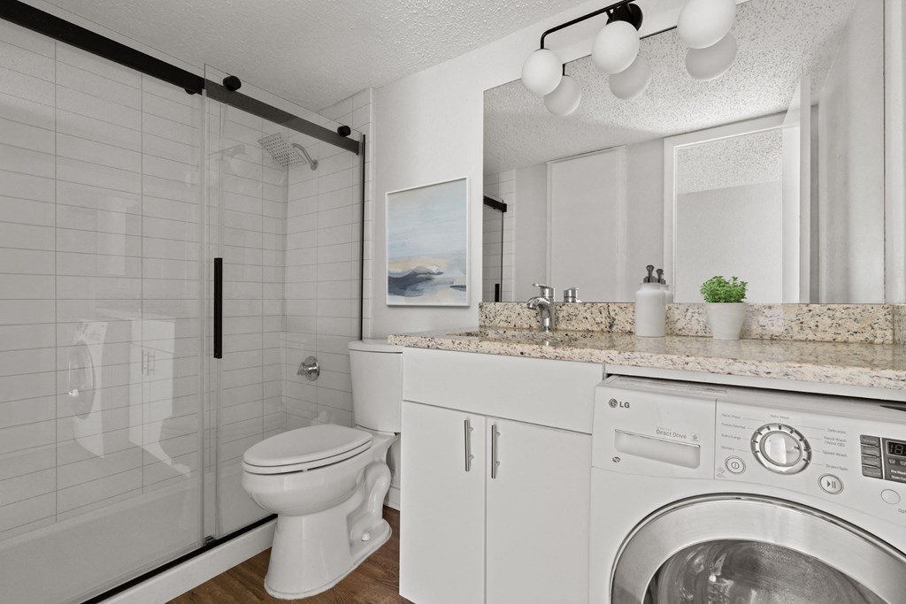a bathroom with a toilet sink and a washing machine at South Lamar Village, Austin, Texas