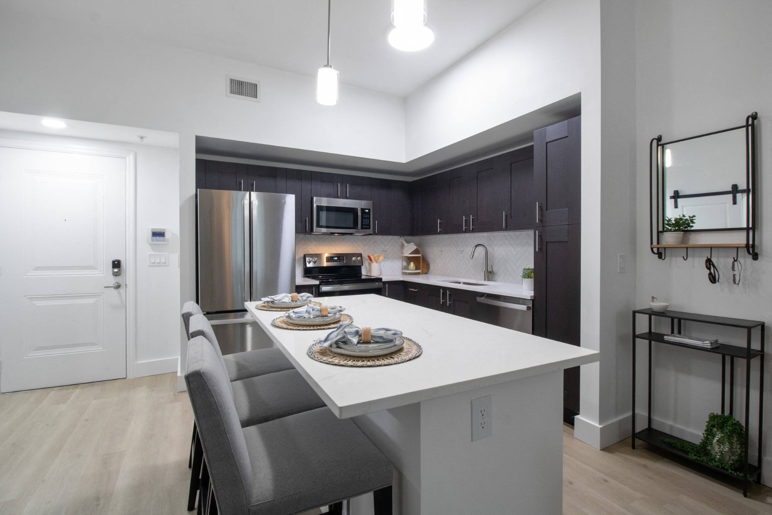 a kitchen with a large island and a stainless steel refrigerator