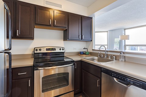 a kitchen with stainless steel appliances and dark wood cabinets