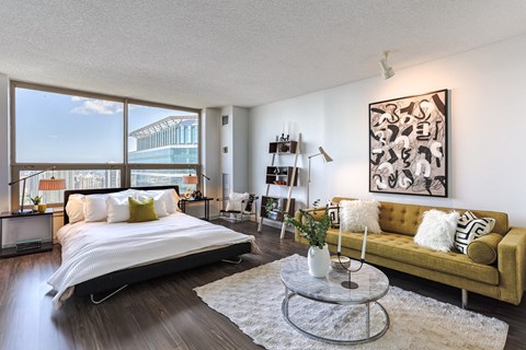 a bedroom with a bed and a couch and a large window at Presidential Towers in IL 60661