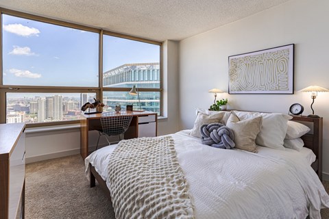 a bedroom with a bed and a view of the city at Presidential Towers in Chicago, IL